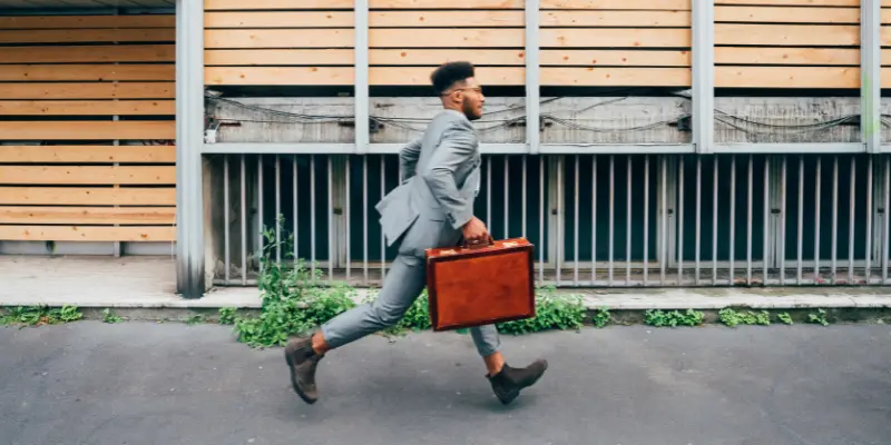 A Man Running Toward His Office May Be He Is Being Late Today.